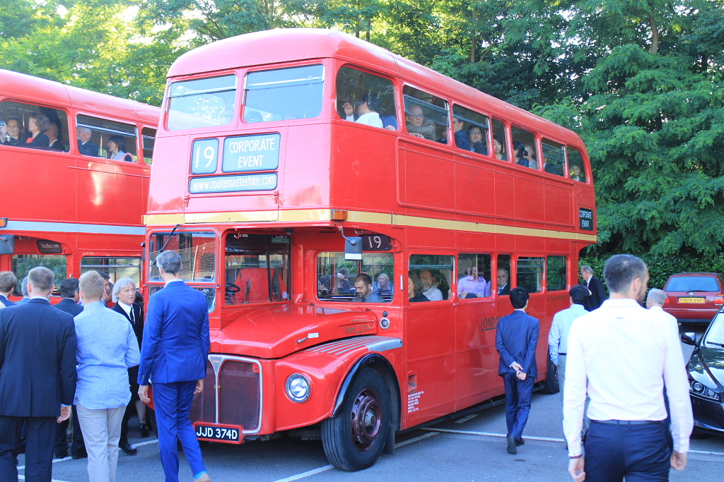 guests walking around red routemaster hire london bus